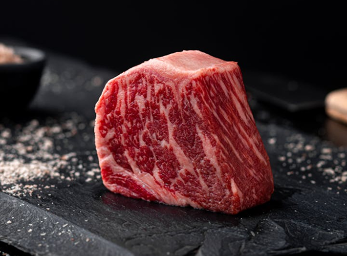 Premium cut of beef on a black slate surface.